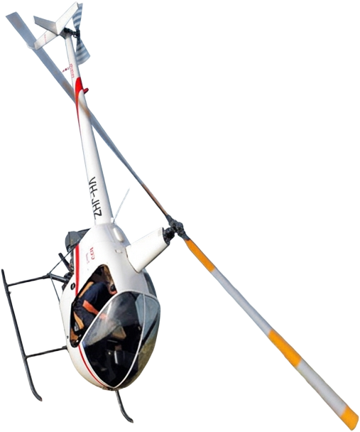A white helicopter banking above the beach